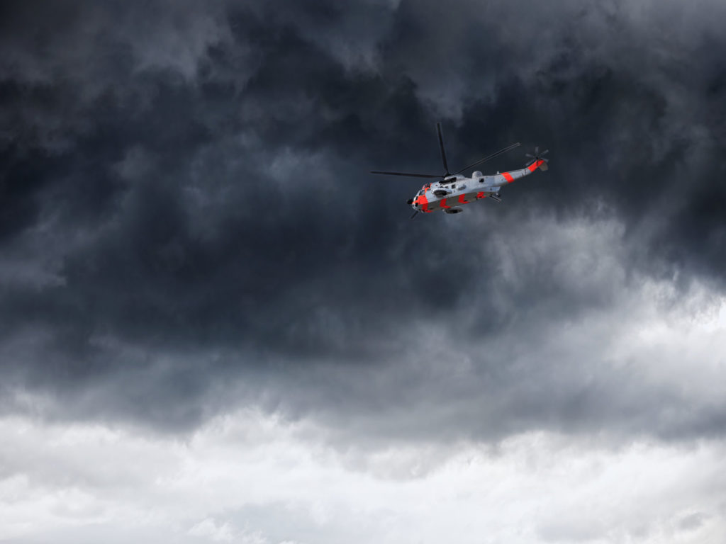 Helicopter in Norway seen from below in front dramatic sky.